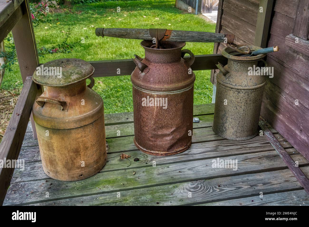 Metal milk cans on the porch of Matt’s Store in the Whippoorwill Academy and Village in Ferguson, North Carolina. Stock Photo