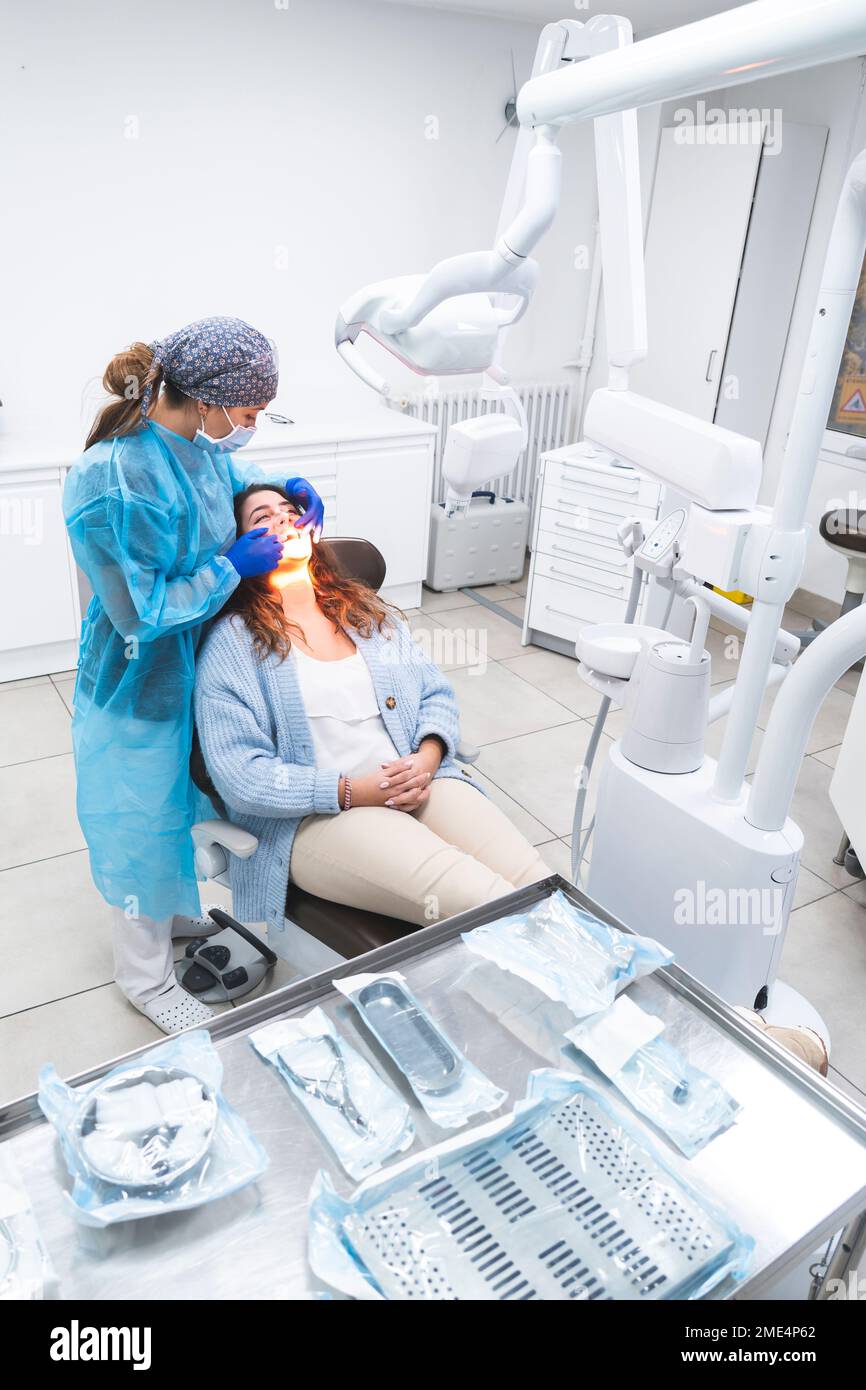 Young dentist examining patient on chair at clinic Stock Photo Alamy