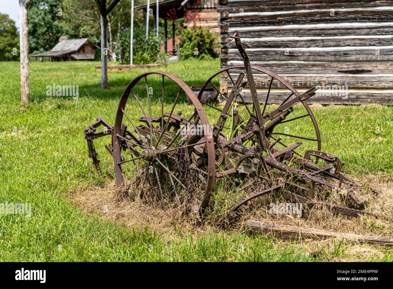 Vintage farm equipment sit outside a shed at the Whippoorwill Academy and Village in Ferguson, North Carolina. Stock Photo