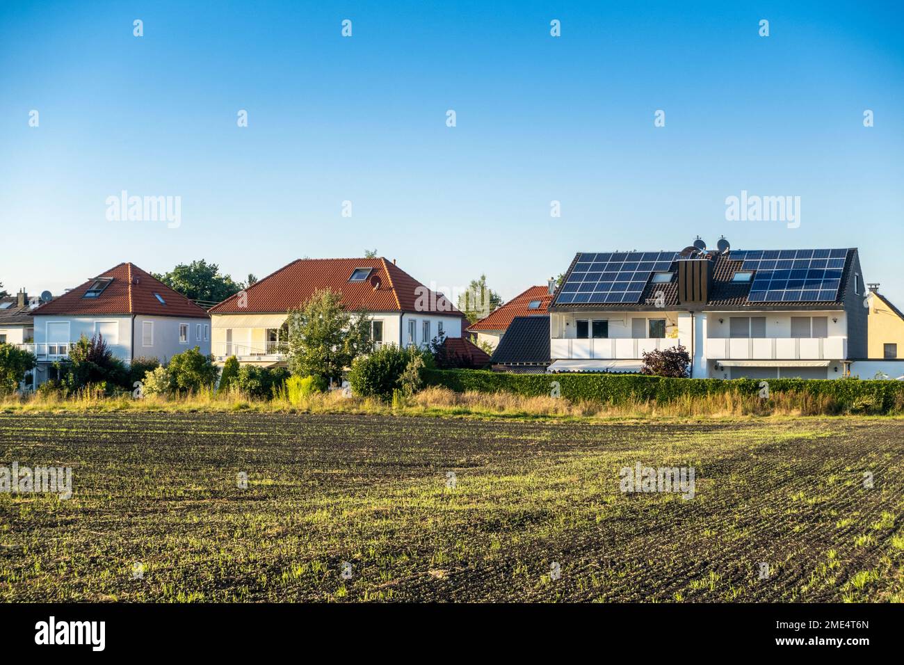 House with solar panels on rooftop under blue sky Stock Photo