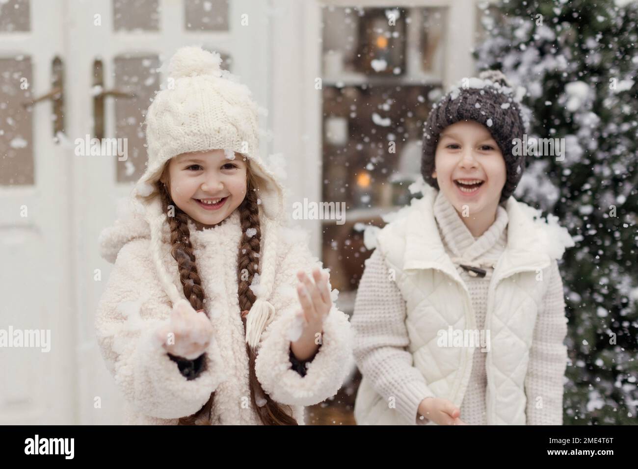 Happy brother and sister enjoying snow at front yard Stock Photo - Alamy