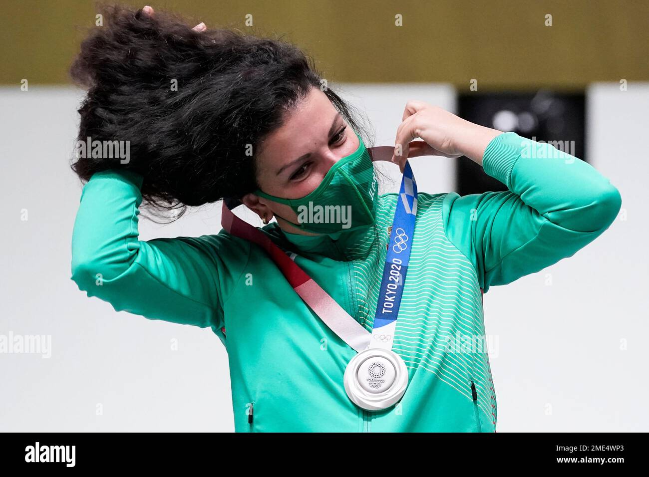 Kostadinova, of Bulgaria, puts on her silver medal for the