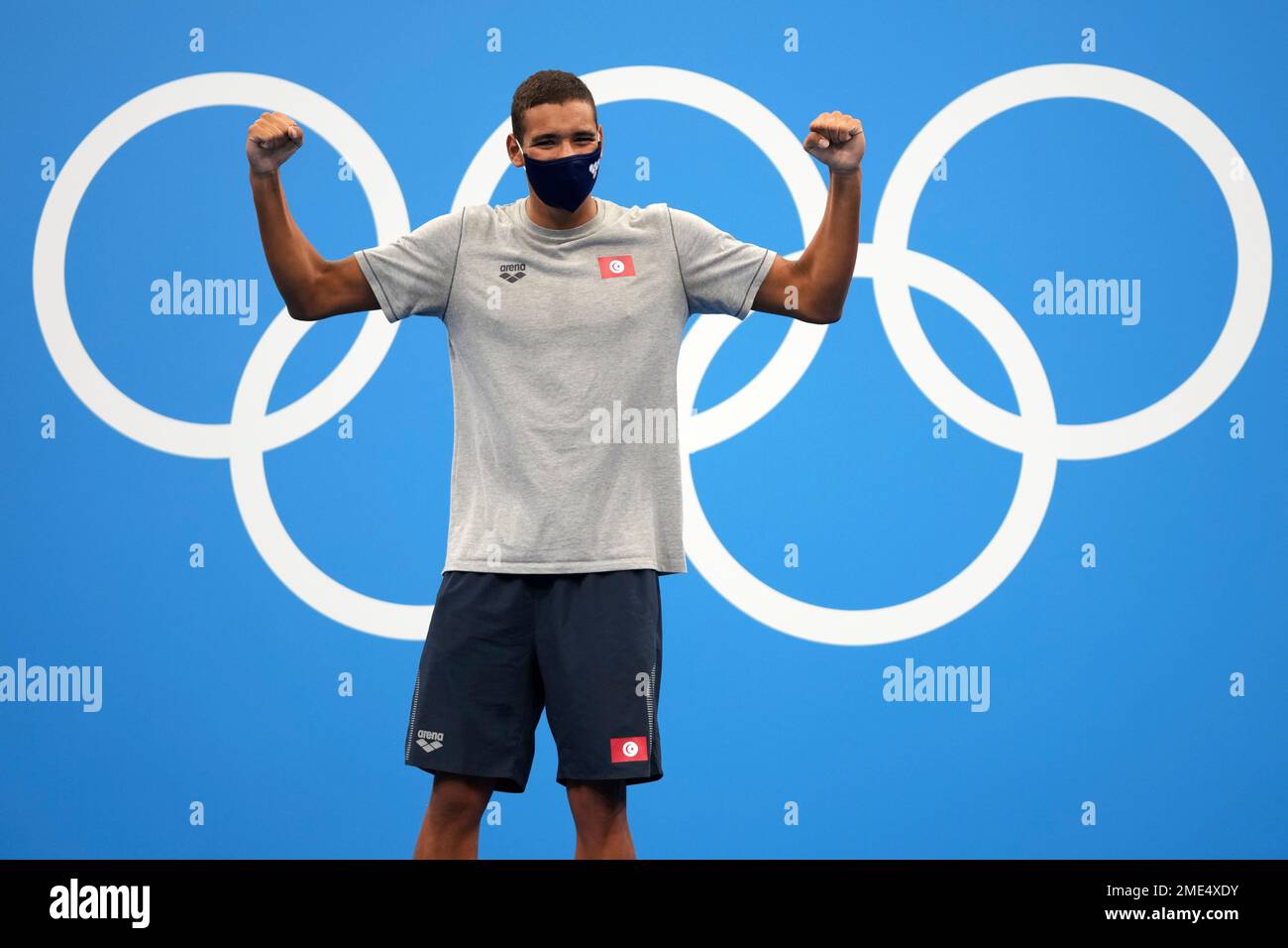 Ahmed Hafnaoui, of Tunisia, celebrates on the podium after winning