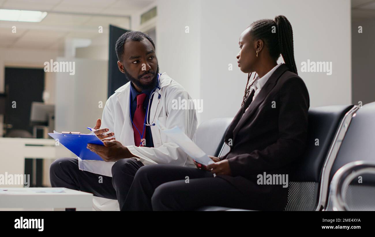 health-specialist-talking-to-woman-about-recovery-in-hospital-reception