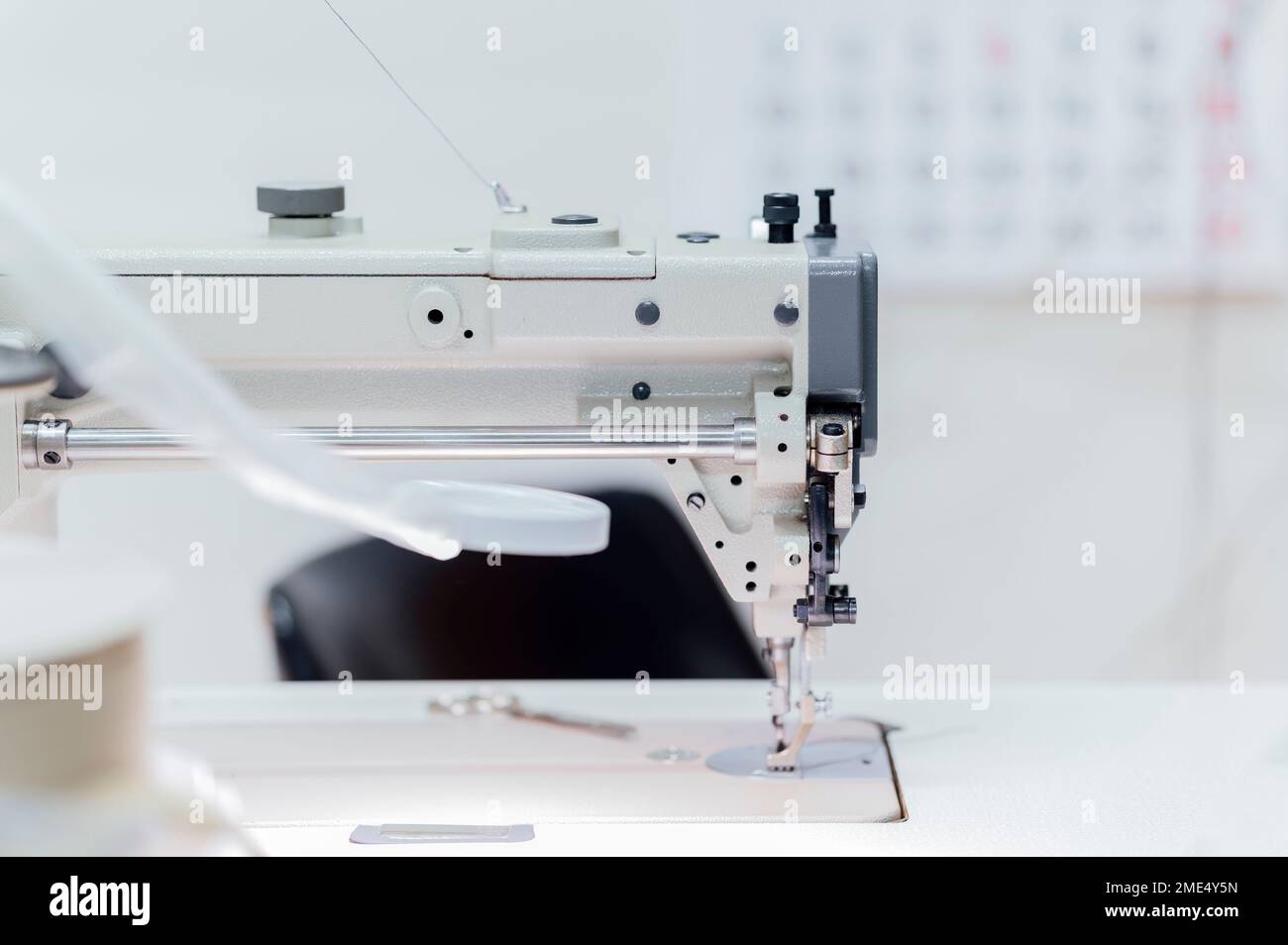 Sewing machine on table in workshop Stock Photo
