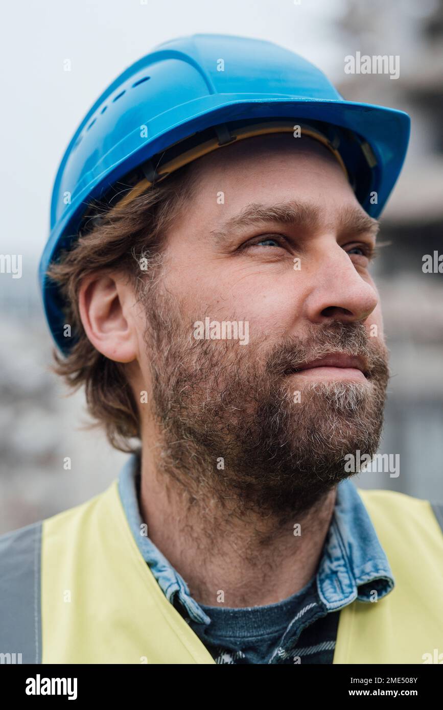 Thoughtful blue-collar worker wearing hardhat Stock Photo