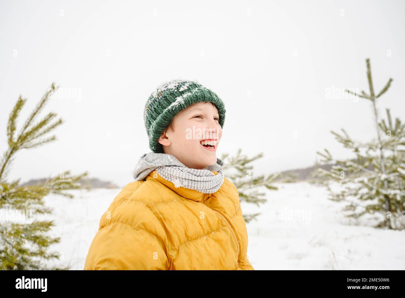 Happy boy wearing knit hat enjoying in front of clear sky Stock Photo