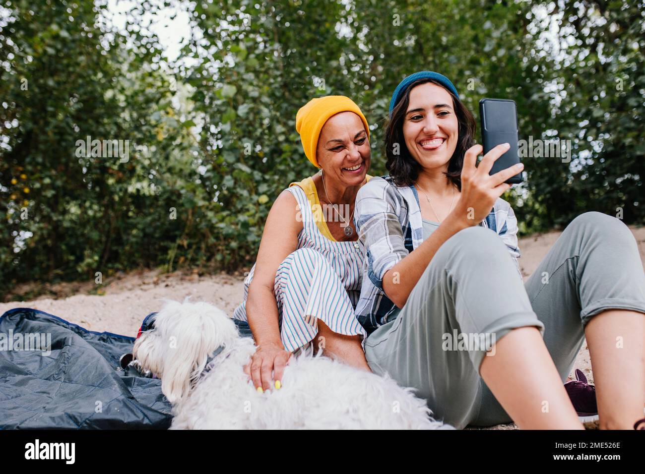 Happy women taking selfie through mobile phone at park Stock Photo
