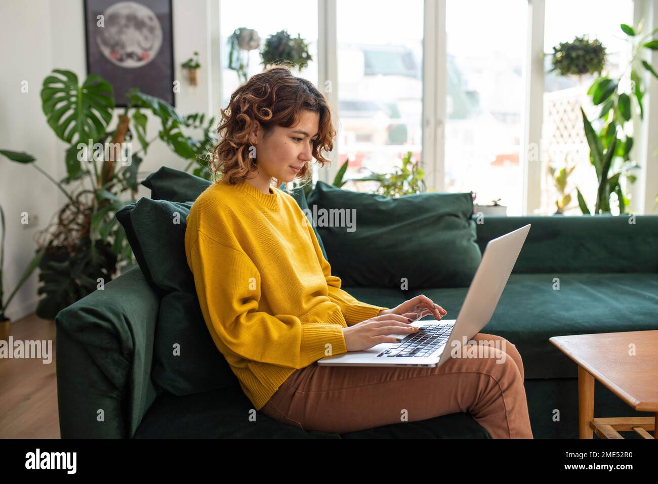 Freelancer working on laptop sitting at home Stock Photo