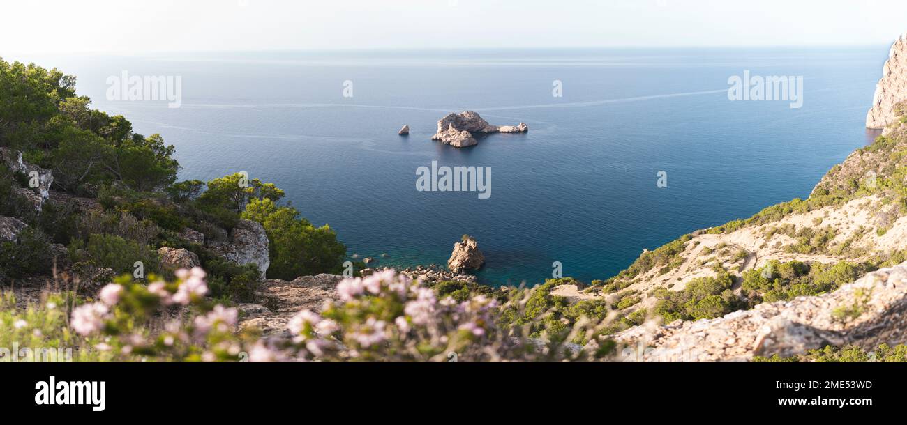 Spain, Balearic Islands, Panoramic view of Ses Margalides rock arch and surrounding sea seen from coastal clifftop Stock Photo