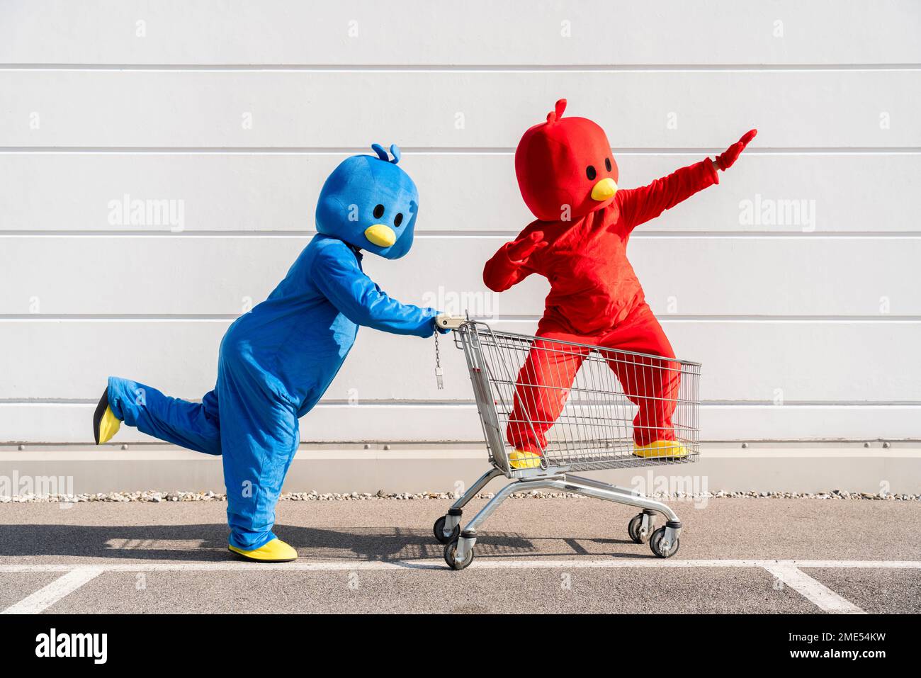 Friends wearing red and blue duck costumes having fun with shopping ...