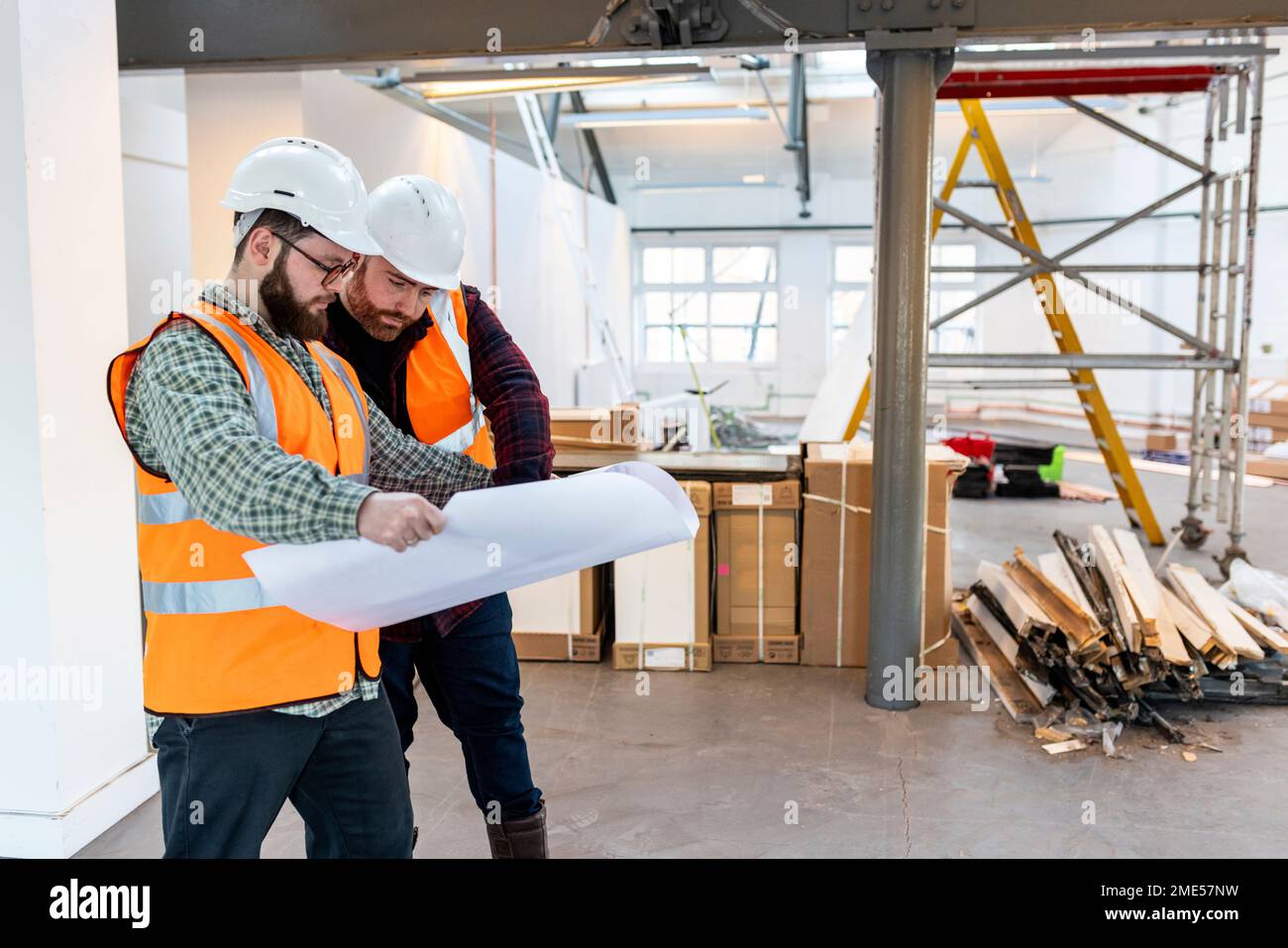 Young engineers discussing over blueprint at construction site Stock Photo