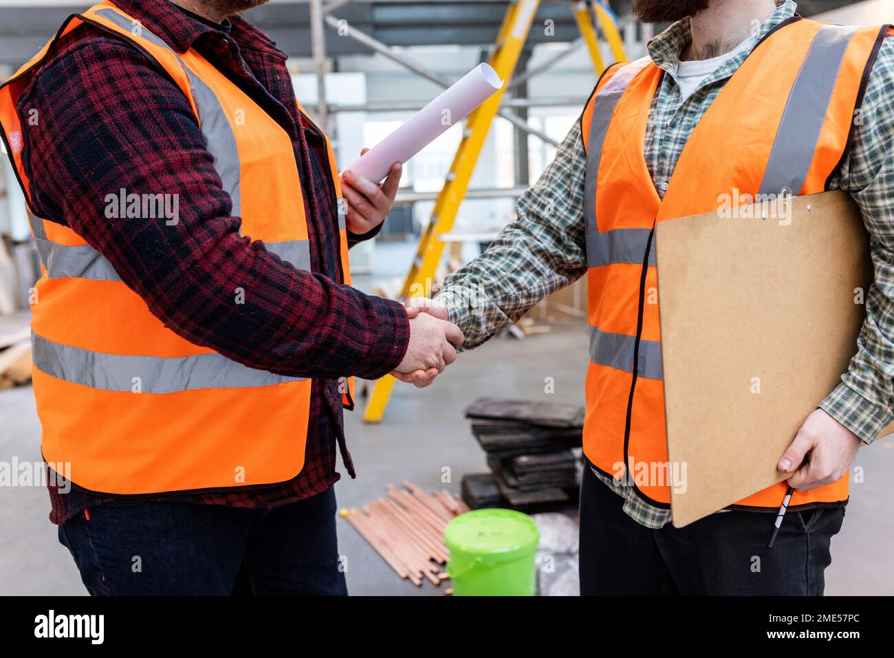 Engineers shaking hands with each other at construction site Stock