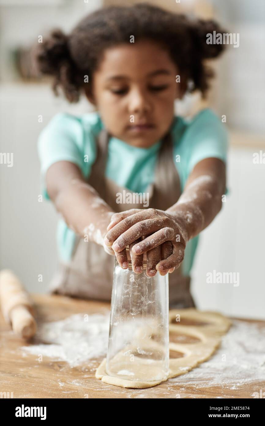 Close up of black little girl baking homemade pastry and cutting cookie