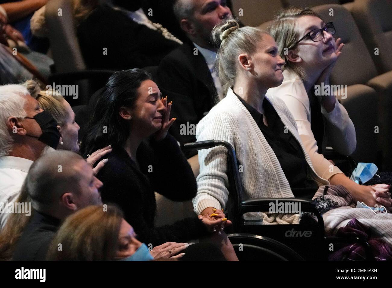 Angela Gonzalez, center right, holds hands with her daughters Tayler
