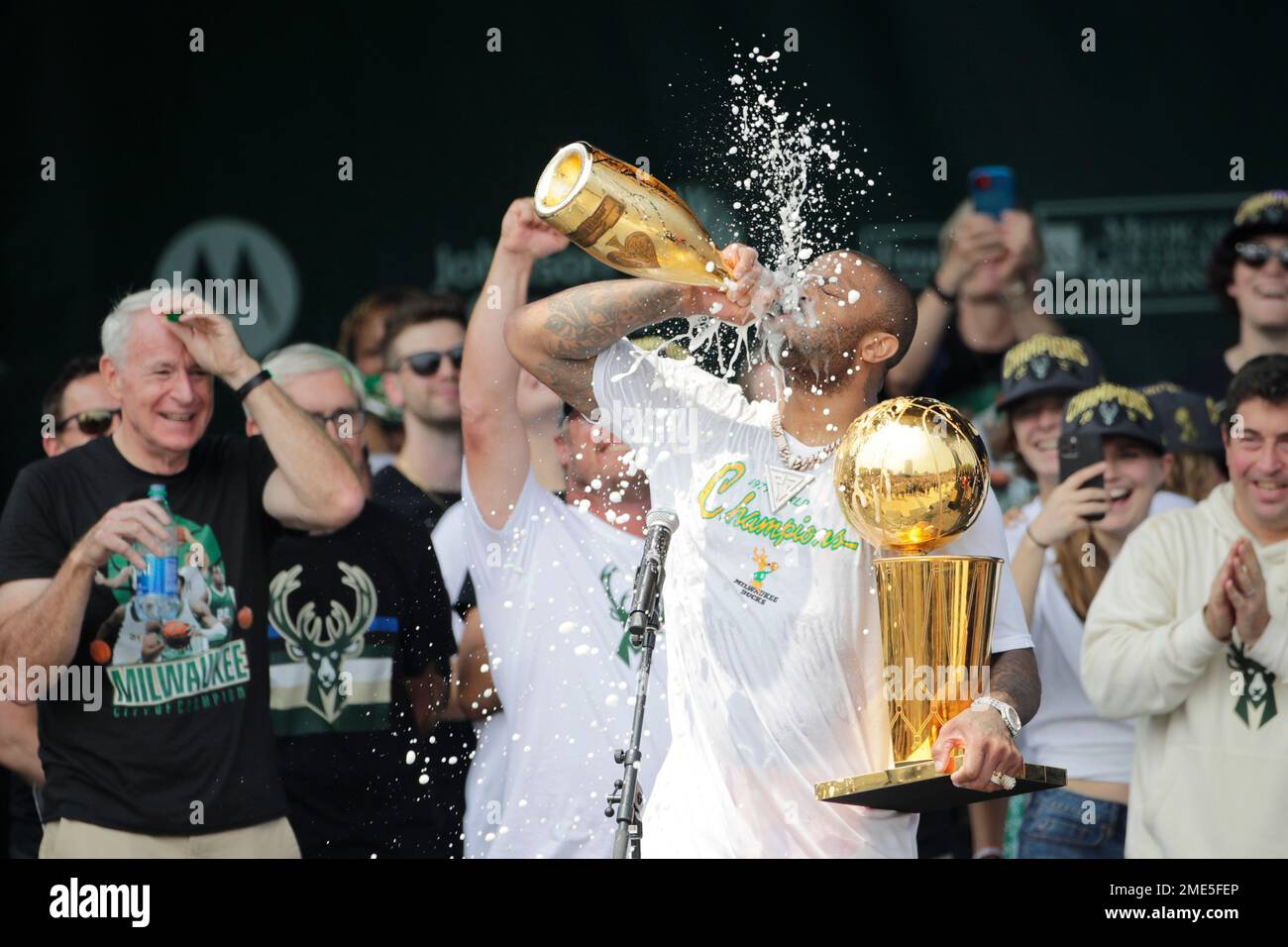 Milwaukee Bucks' P.J. Tucker drinks Champagne as he holds