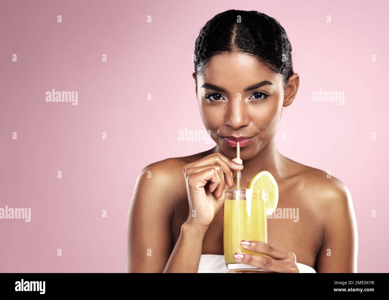 Drink up and glow up. a beautiful young woman drinking a glass of fruit