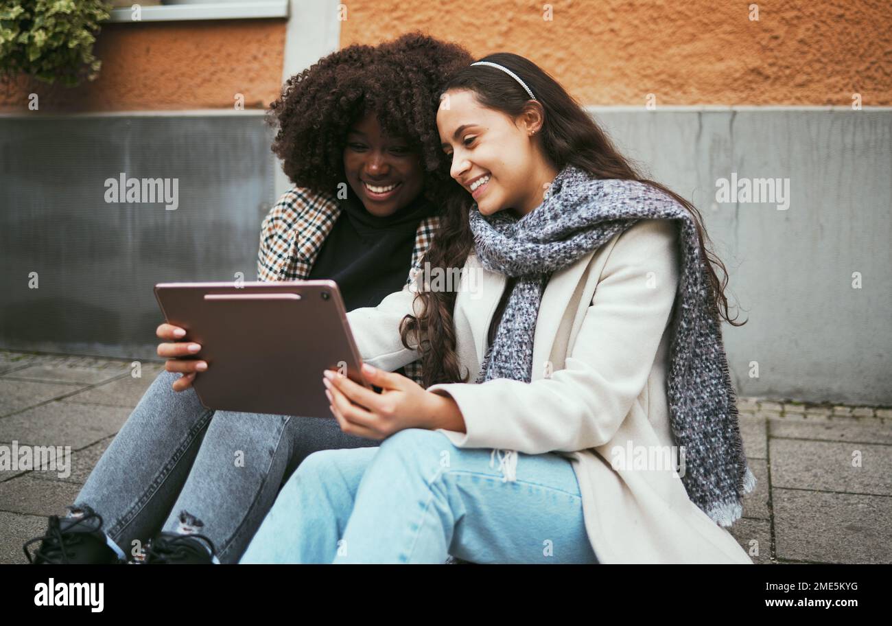 Women, fashion or tablet on travel blogging, location search or social media on London road, street or sidewalk. Smile, happy or bonding friends on Stock Photo