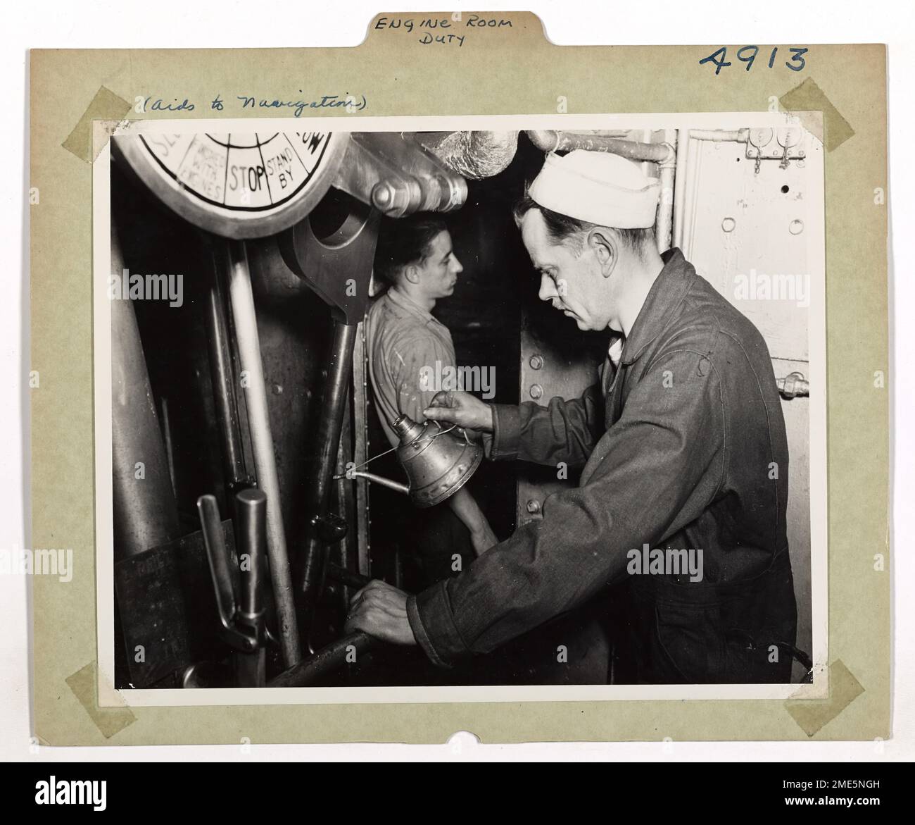 Engine Room Duty. An 'Oil Can Jockey' does his stuff on the valve gear of the main engines aboard the Coast Guard light ship 'Columbia River', No. 93. The home port of this ship is Astoria, Oregon. Stock Photo