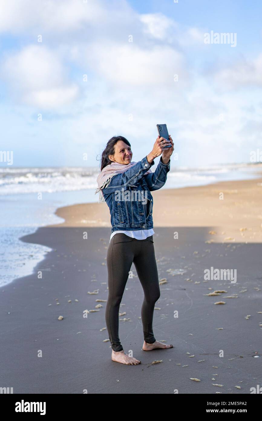 Portrait of a woman taking selfies on the beach Stock Photo