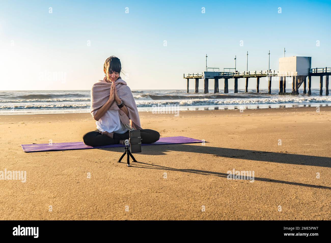 Slim woman yoga instructor giving online yoga training in a mobile phone  camera. Yoga and meditation for social net Stock Photo - Alamy
