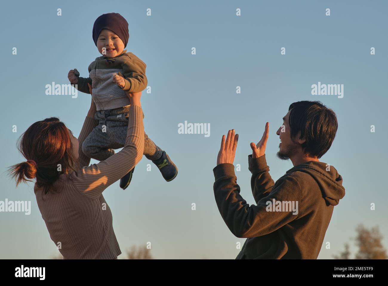 Happy mom and dad asians hold their son in their arms and smile Stock ...