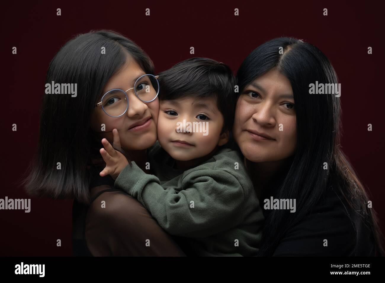 mexican mother hugging and smiling with song and daughter Stock Photo