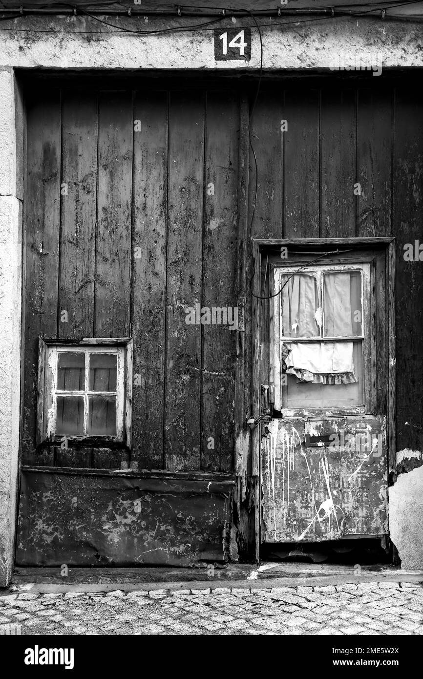 Lisbon, Portugal- November 18, 2022:Old wooden door with curtain and wrought iron details in Lisbon city, Portugal Stock Photo