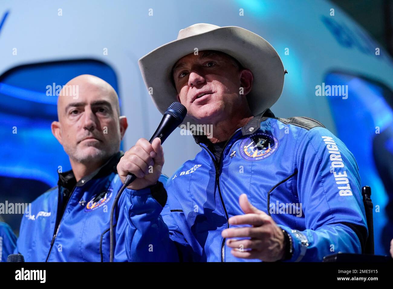 Mark Bezos, left, listens as his brother Jeff Bezos, founder of Amazon