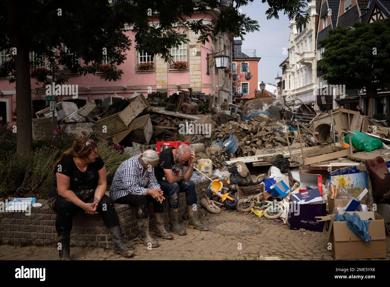 People Rest From Cleaning Up The Debris Of The Flood Disaster In.