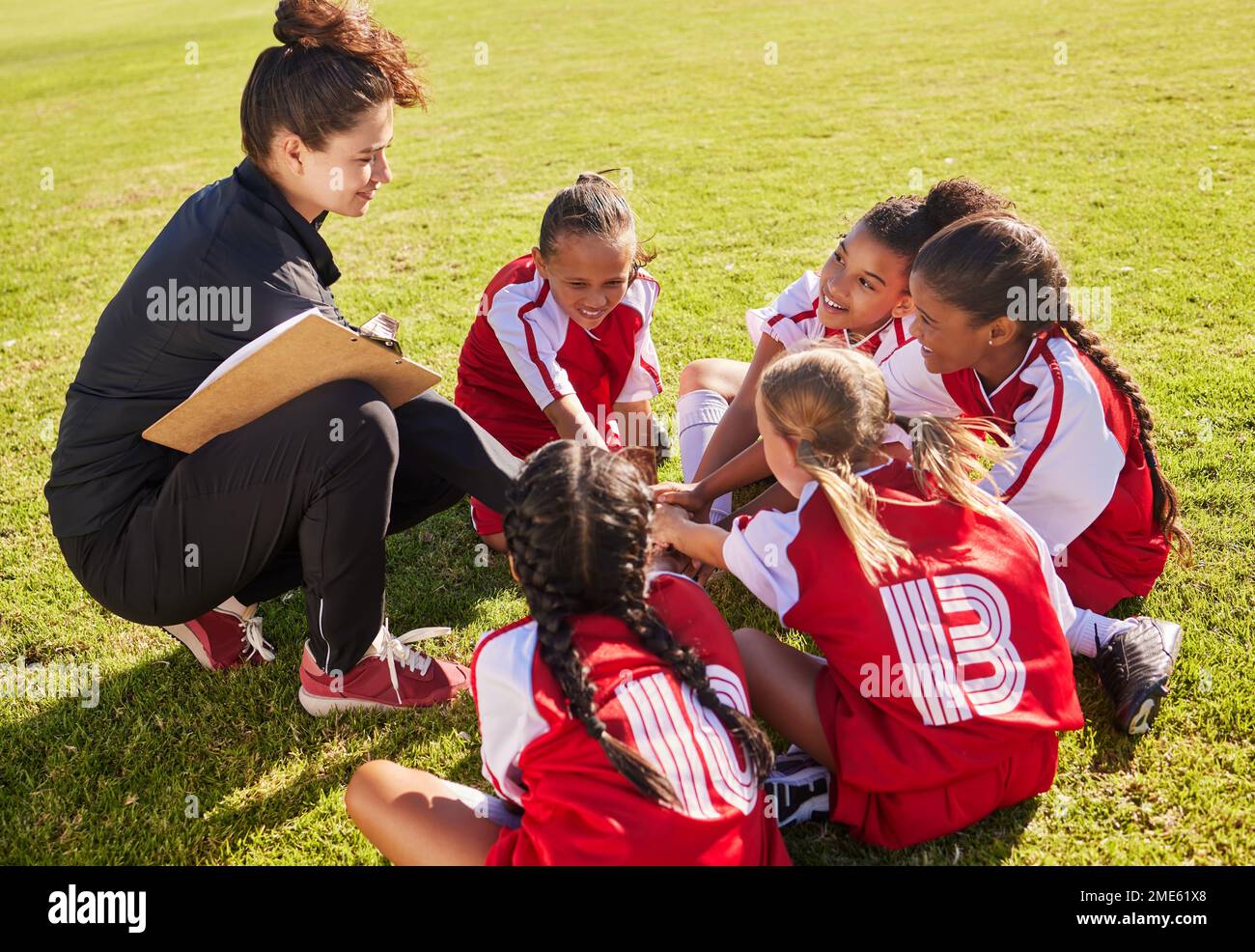 Huddle, sport or coach with children hands for soccer strategy training or team goals in Canada. Team building, circle or woman and group of girls on Stock Photo