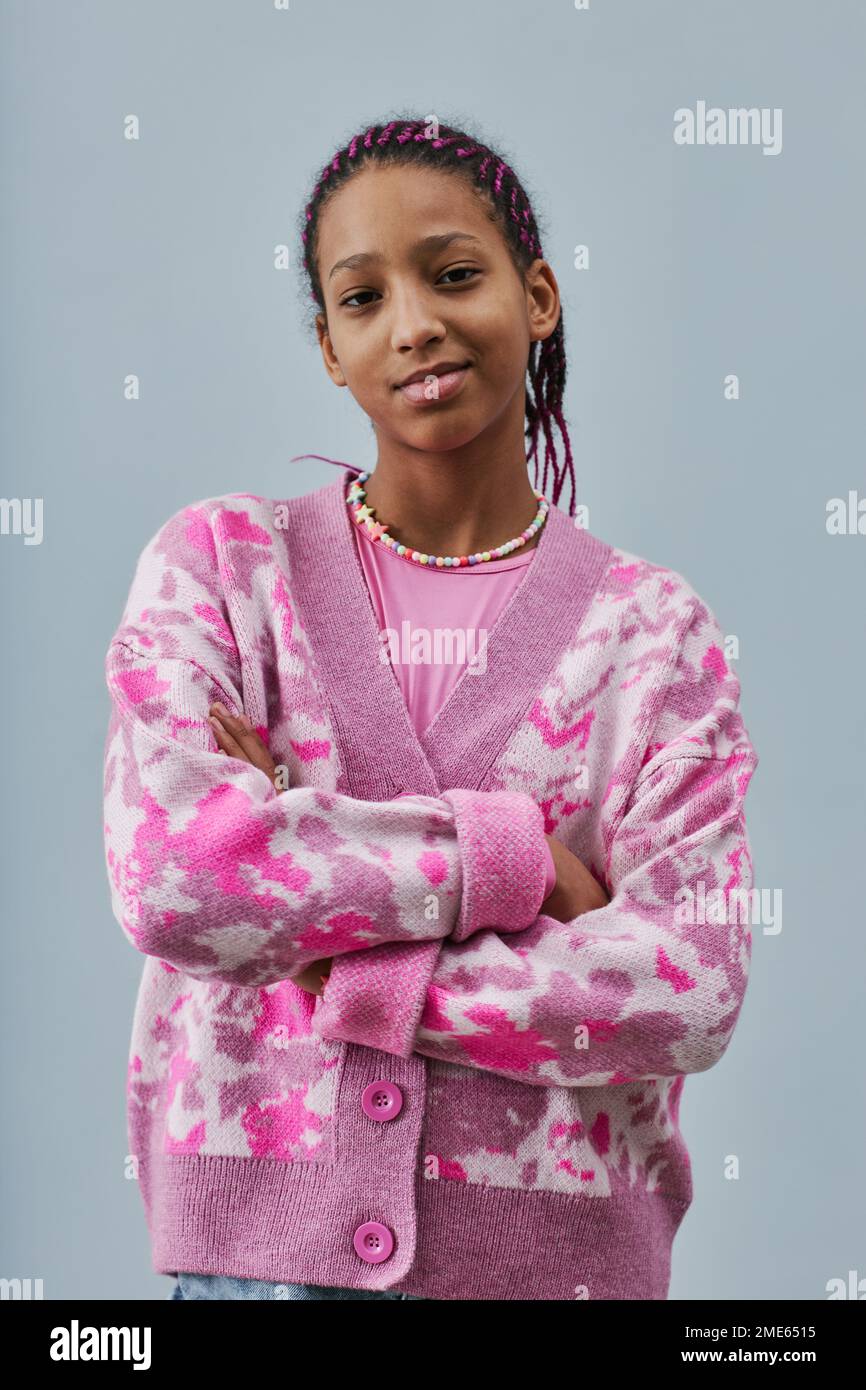 Vertical portrait of black teenage girl wearing pink trendy clothes and ...