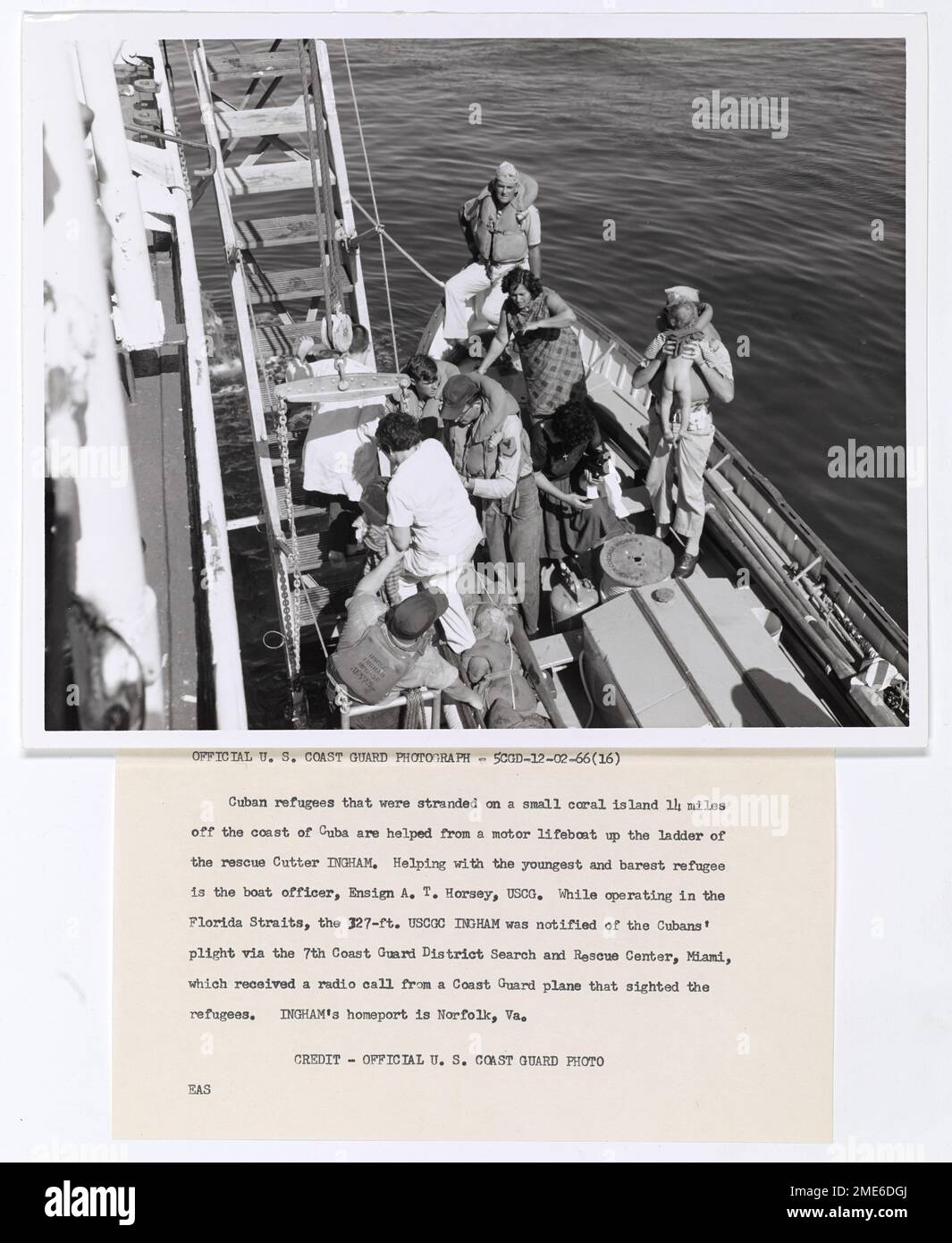 Photograph of Cuban Refugees - USCGC Ingham Operating in Florida Straits. Cuban refugees that were stranded on a small coral island 14 miles off the coast of Cuba are helped from a motor lifeboat up the ladder of the rescue Cutter Ingham. Helping with the youngest and barest refugee is the boat officer, Ensign A.T. Horsey, USCG. While operating in the Florida Straits, the 327-ft USCGC Ingham was notified of the Cubans' plight via the 7th Coast Guard District Search and rescue Center, Miami, which received a radio call from a Coast Guard plane that sighted the refugees. Ingham's homeport is Nor Stock Photo