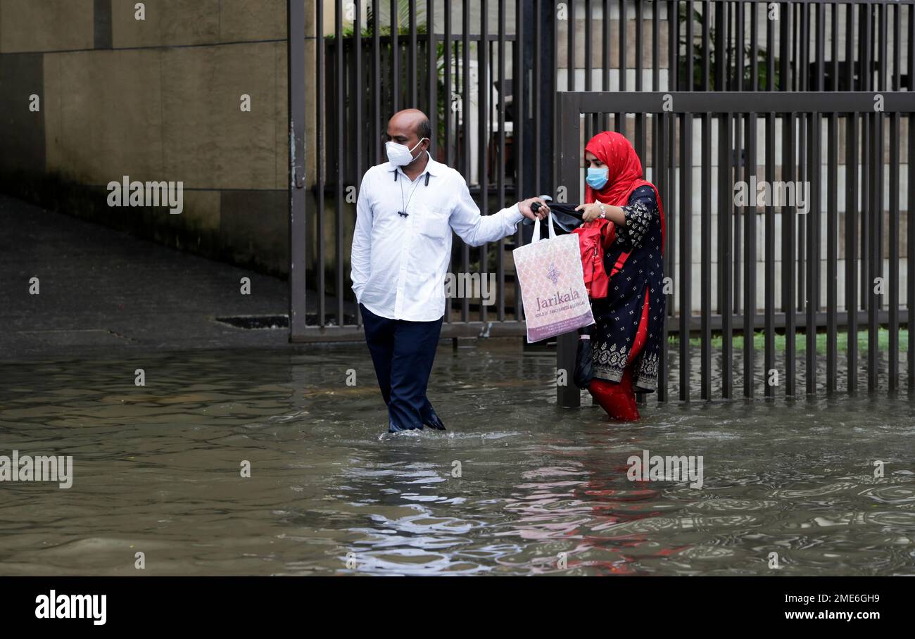 People Make Their Way Through A Waterlogged Street After Heavy Rainfall In Mumbai India Friday