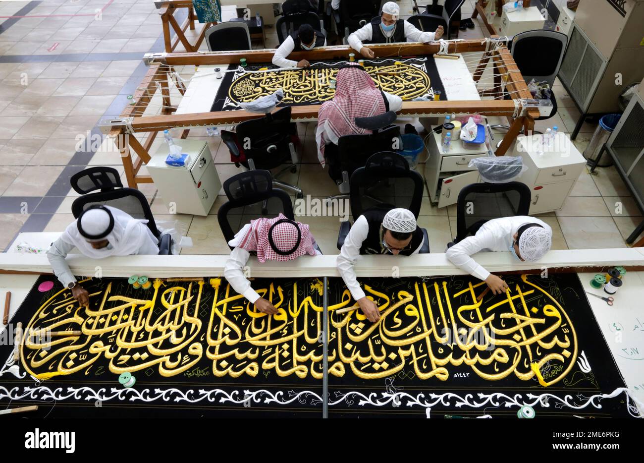 Saudi workers embroider Islamic calligraphy, using either pure silver