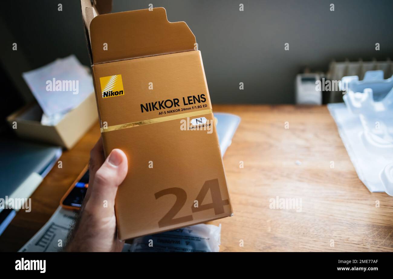 Paris, France - Jan 16, 2023: POV personal perspective male hand holding  cardboard package of open new NIkon AF-s Nikkor 25mm f 1.8 G ED lens for  DSLR camera Stock Photo - Alamy