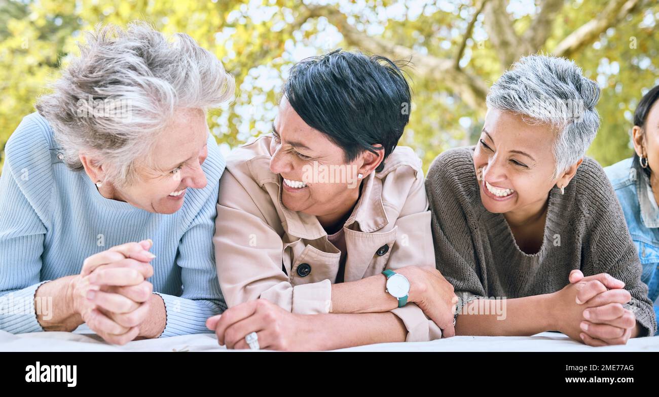 Retirement, women and friends laugh at park together for bonding, wellness and relaxing lifestyle. Happiness, funny and smile of senior people in Stock Photo