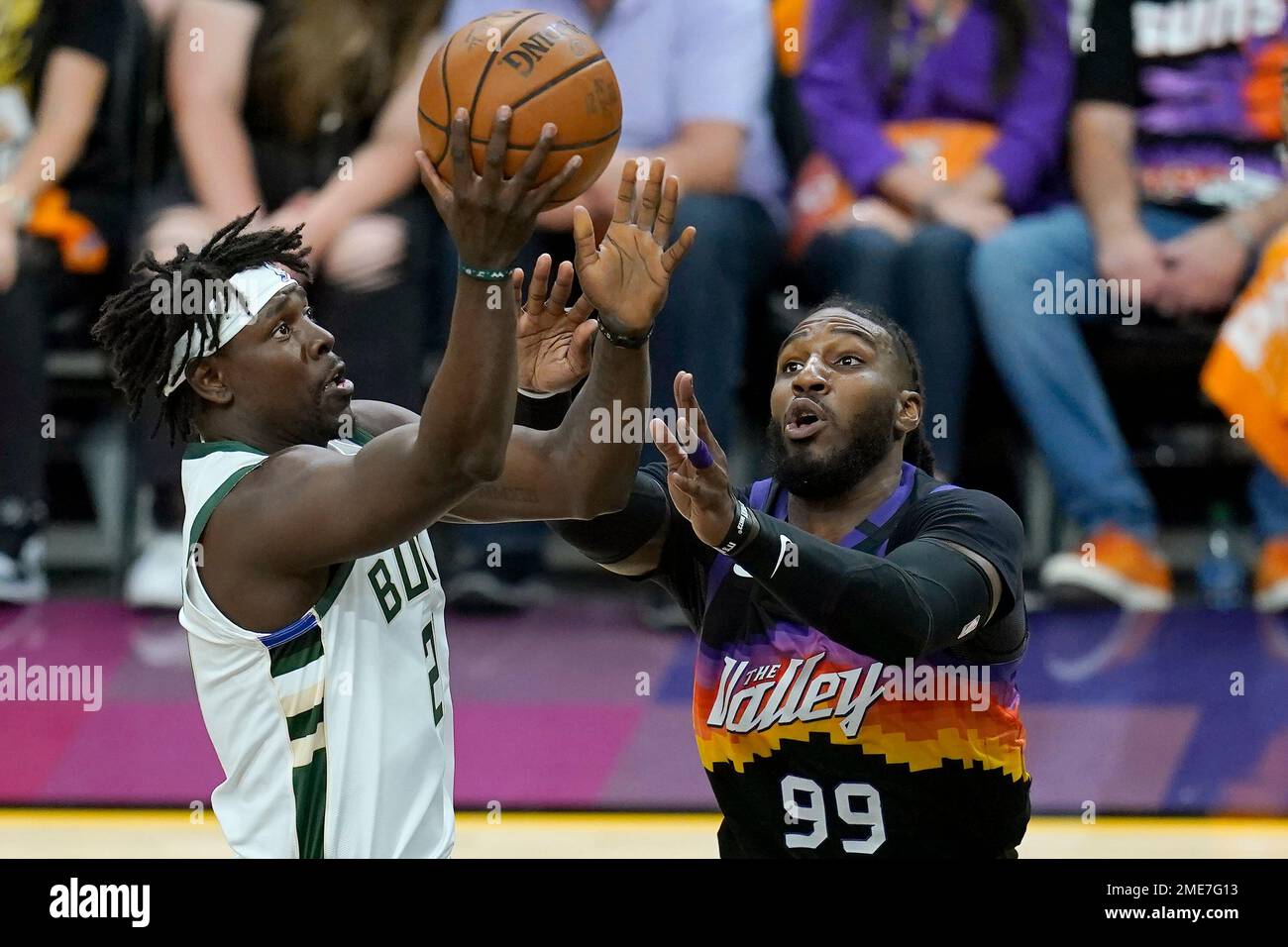 Milwaukee Bucks guard Jrue Holiday, left, shoots against Phoenix Suns forward Jae Crowder (99