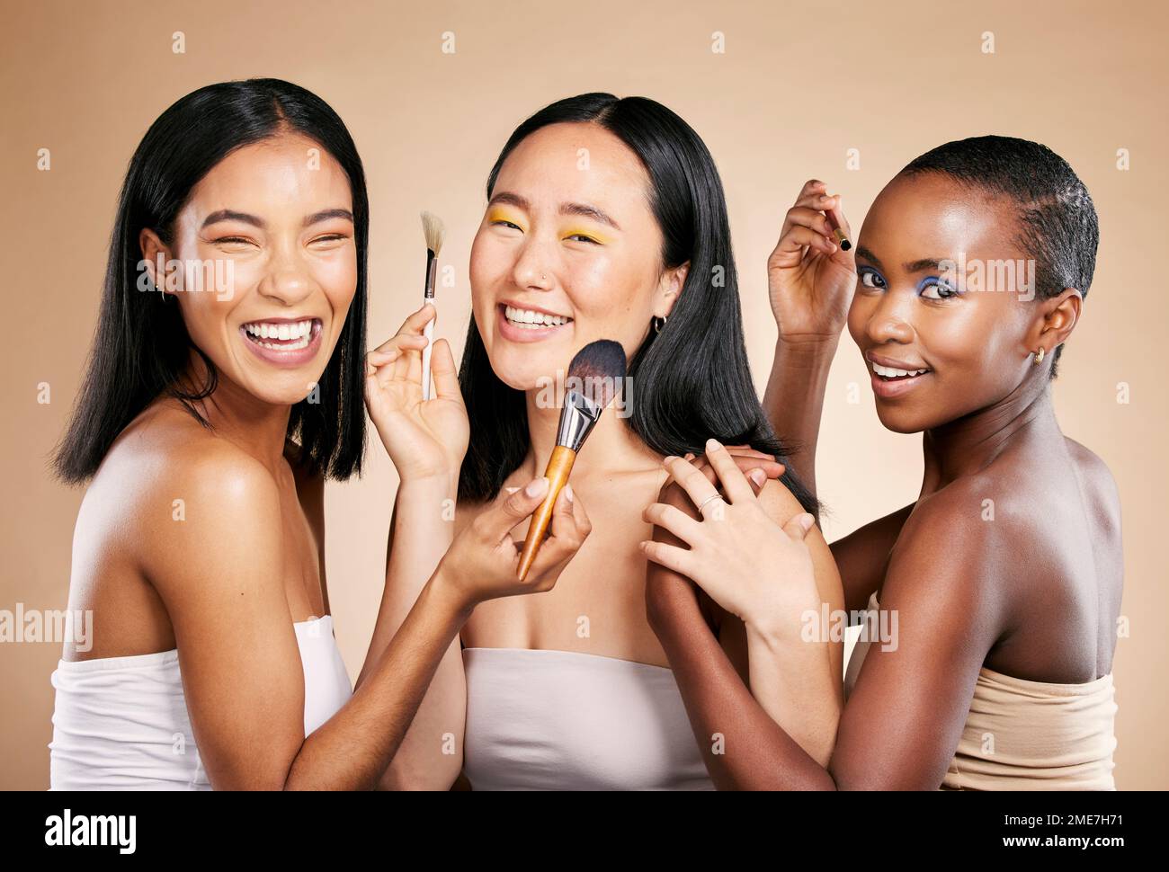 Diversity, smile and woman with makeup tools products for facial skincare, cosmetics dermatology and skin wellness. Interracial models, happy face Stock Photo
