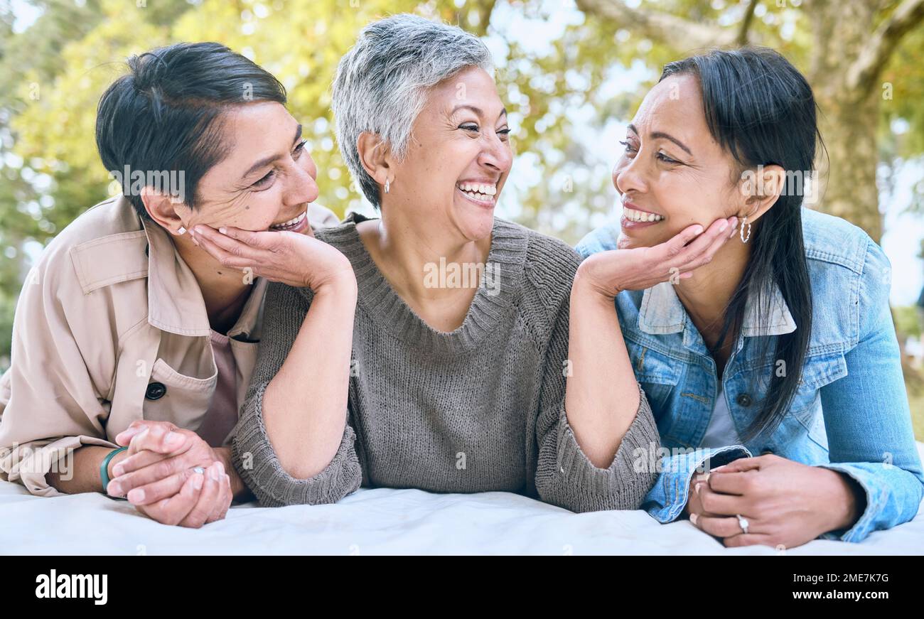 Love, senior women and friends at park on picnic blanket, bonding and enjoying quality time together outdoors. Peace, retirement and happy group of Stock Photo