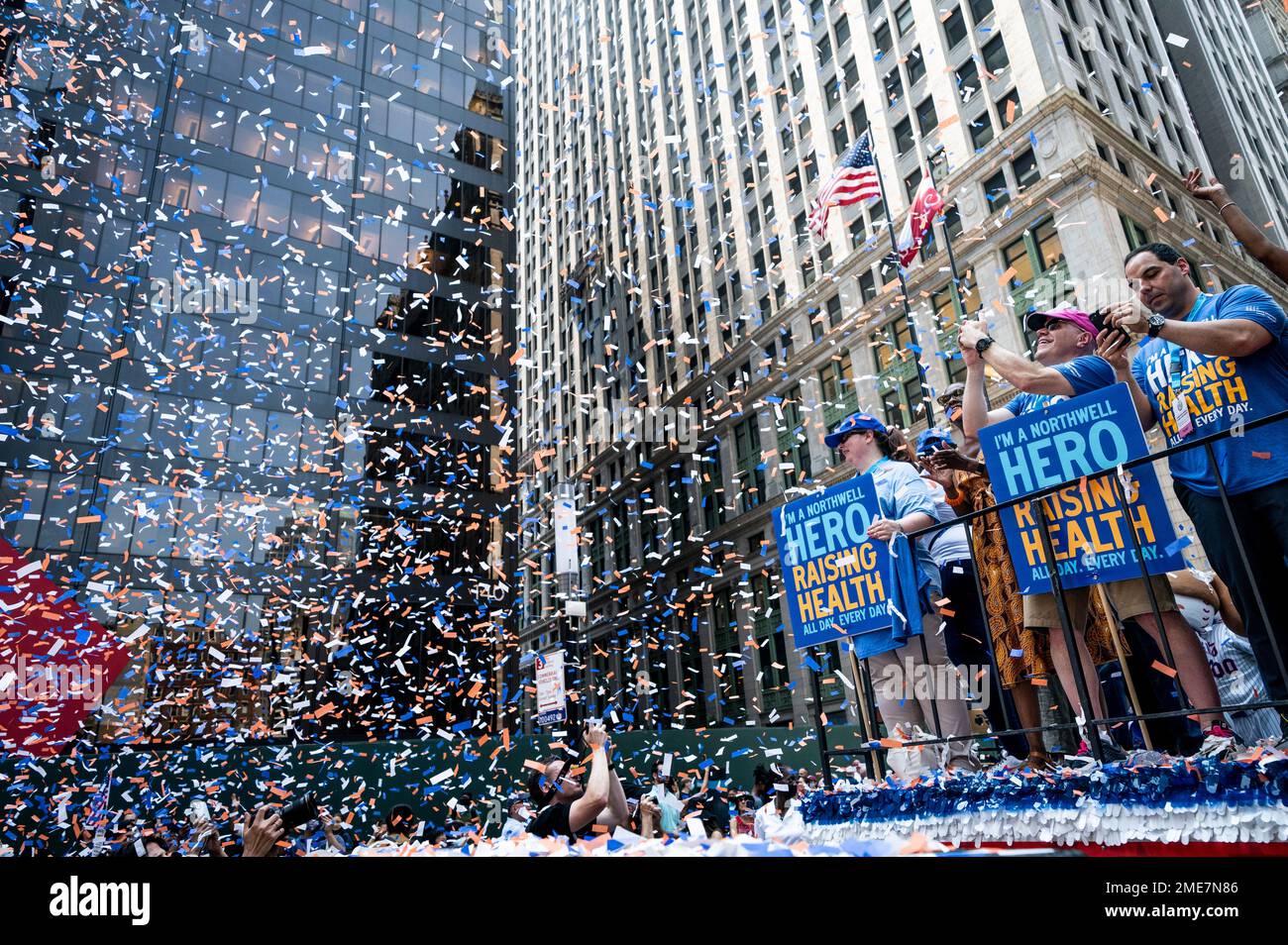 Participants on floats pass through a cloud of confetti on Broadway ...