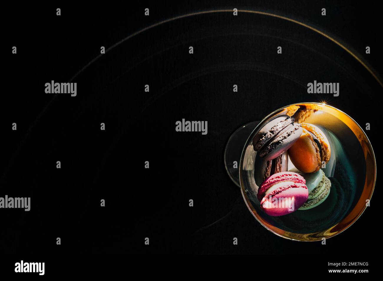 Colorful Macaron Cookies in Gold Glass on Black Background Stock Photo ...