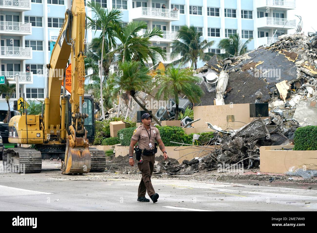 A police officer walks past the collapsed and demolished Champlain