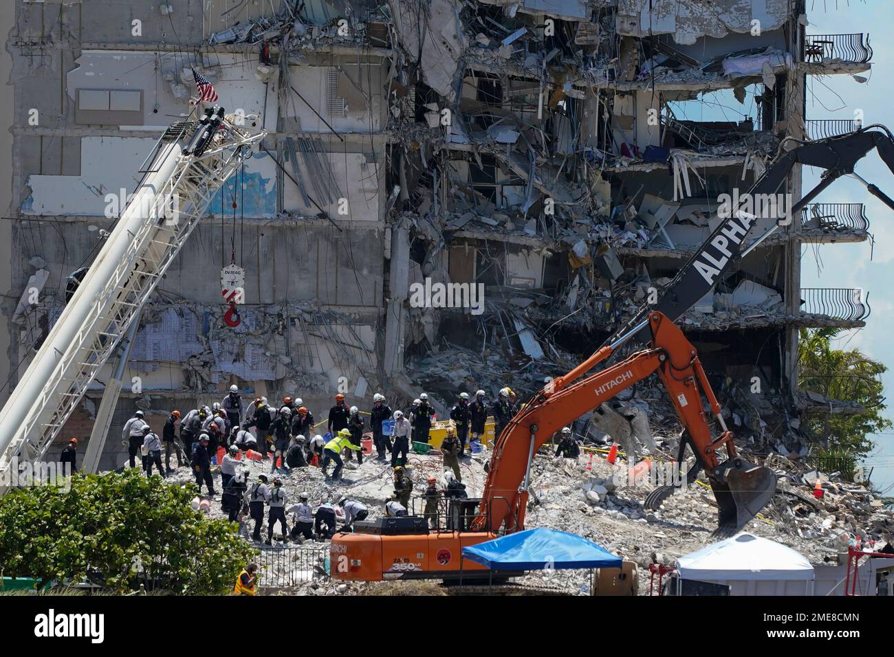 Search and rescue personnel work atop the rubble at the Champlain ...