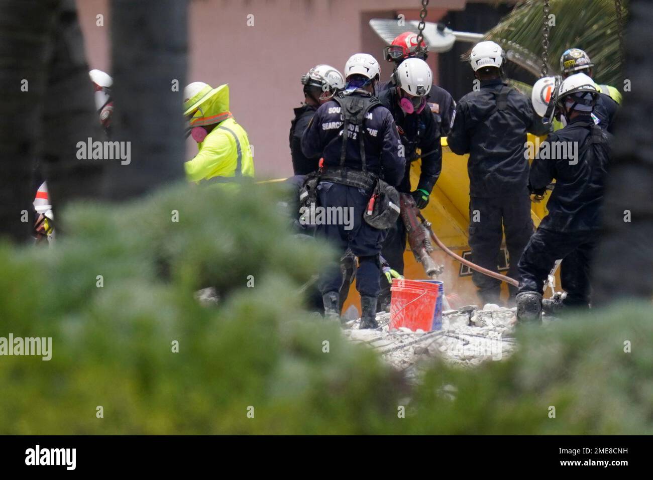 Search and rescue personnel work atop the rubble at the Champlain ...