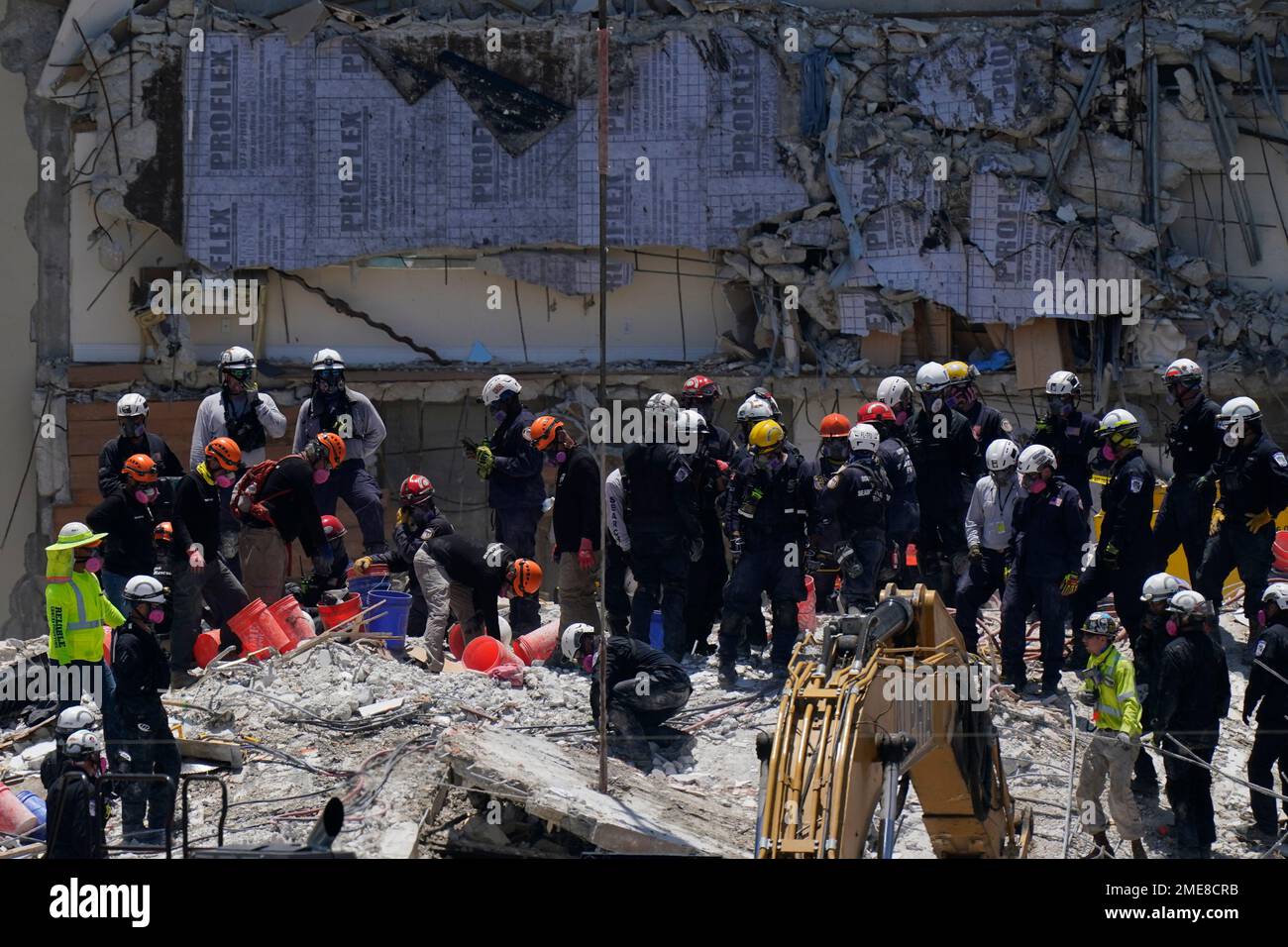 Search and rescue personnel work atop the rubble at the Champlain ...