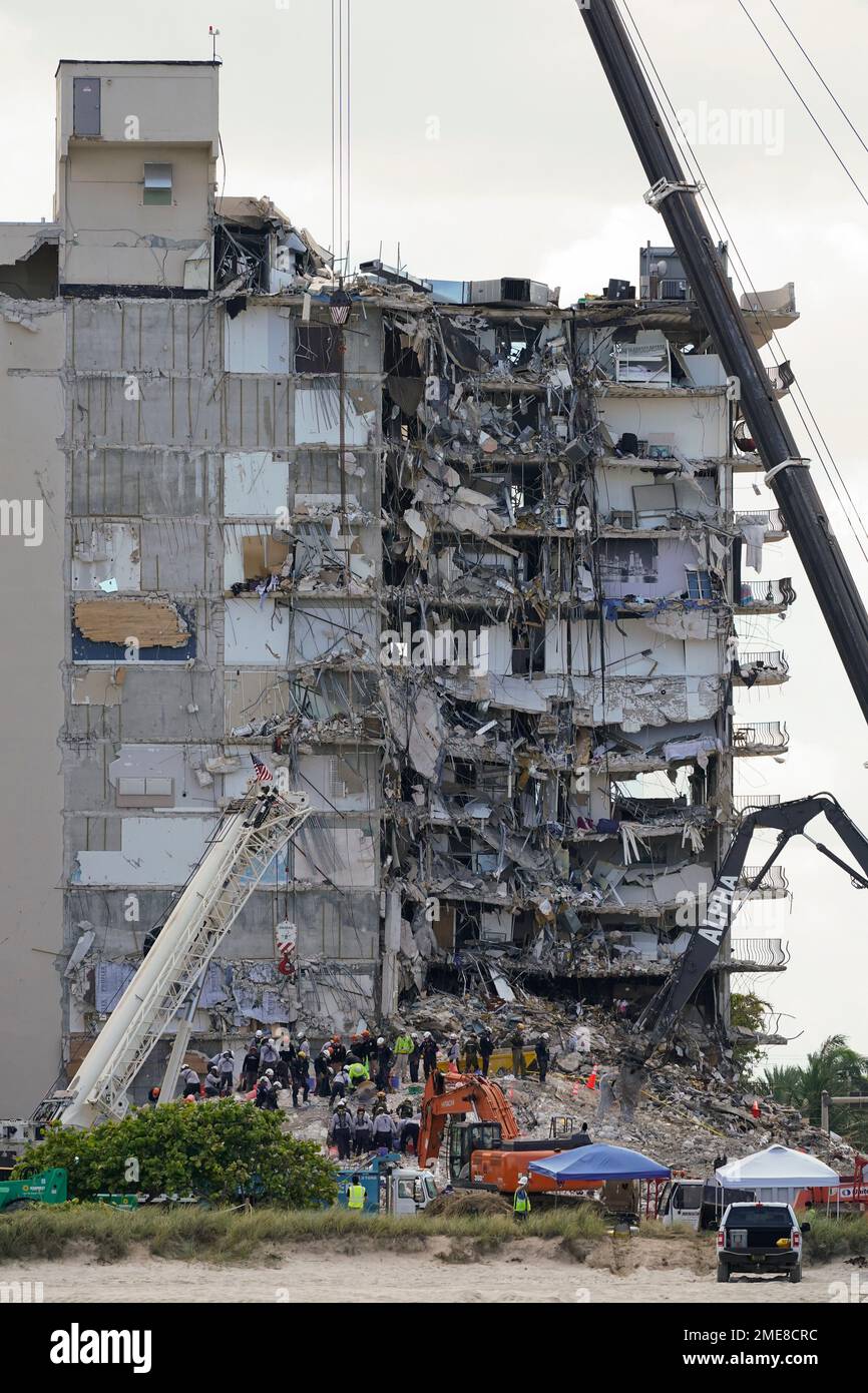 Search and rescue personnel work atop the rubble at the Champlain ...