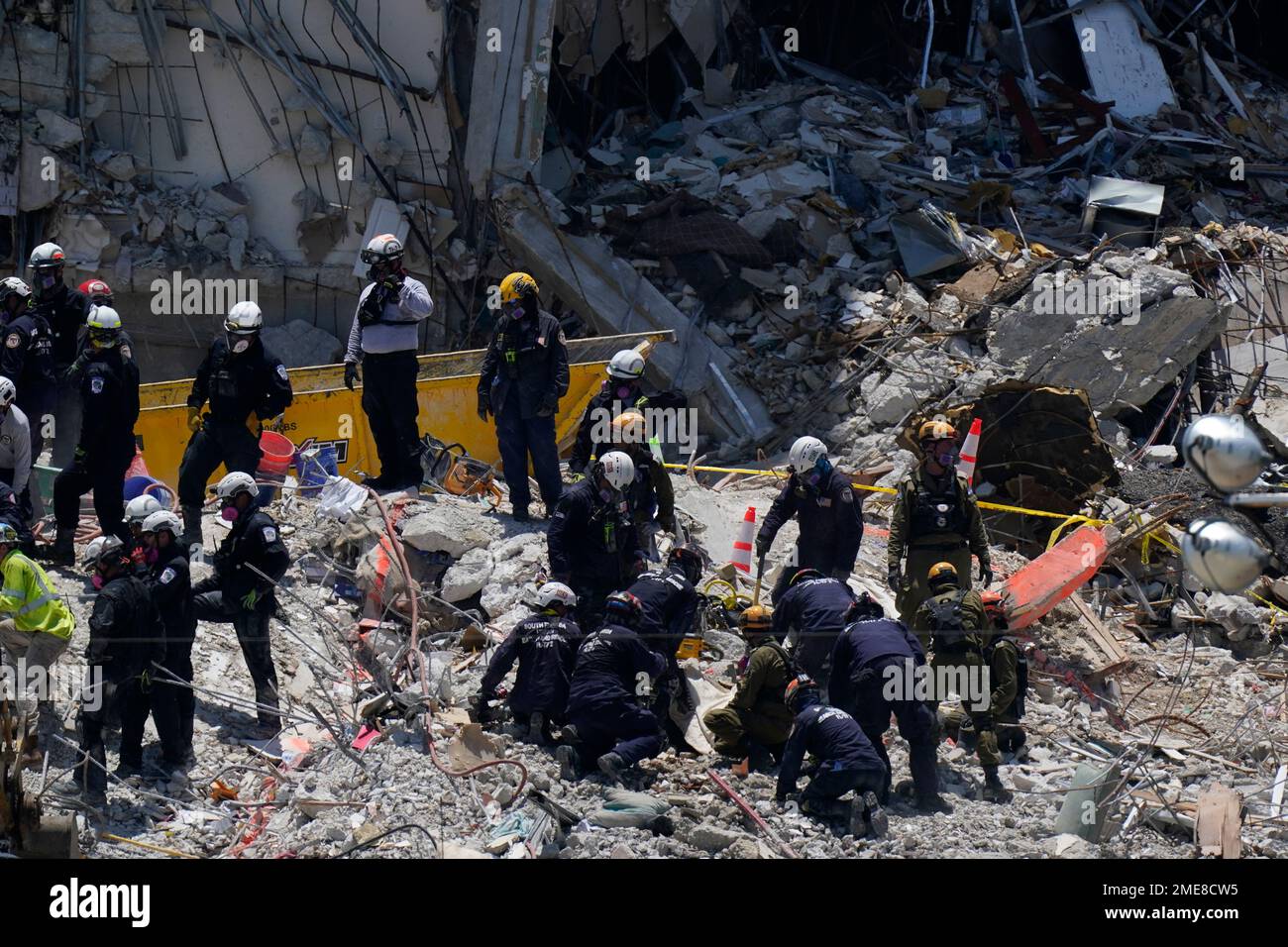Search and rescue personnel work atop the rubble at the Champlain ...