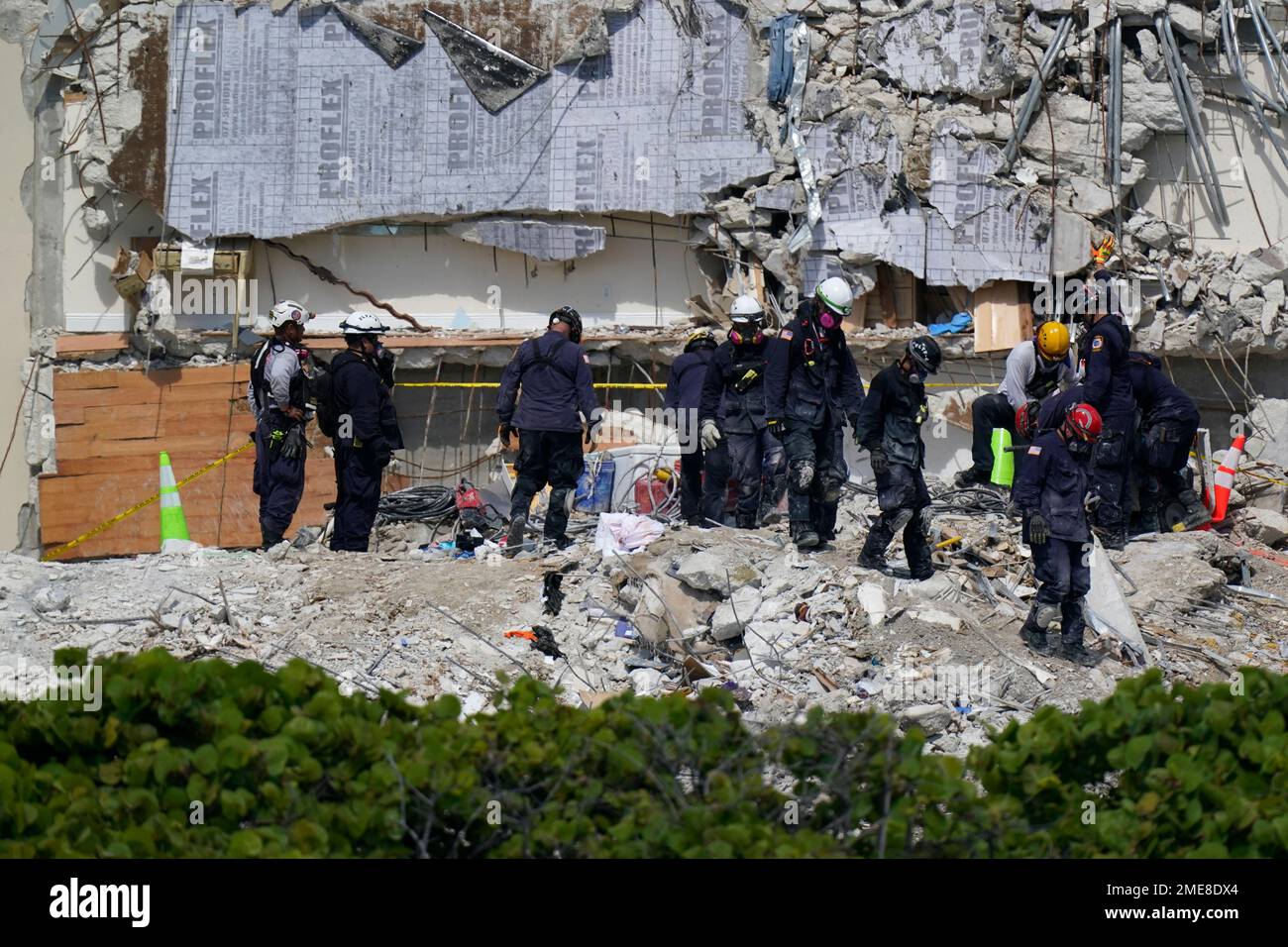 Search and rescue personnel work atop the rubble at the Champlain ...