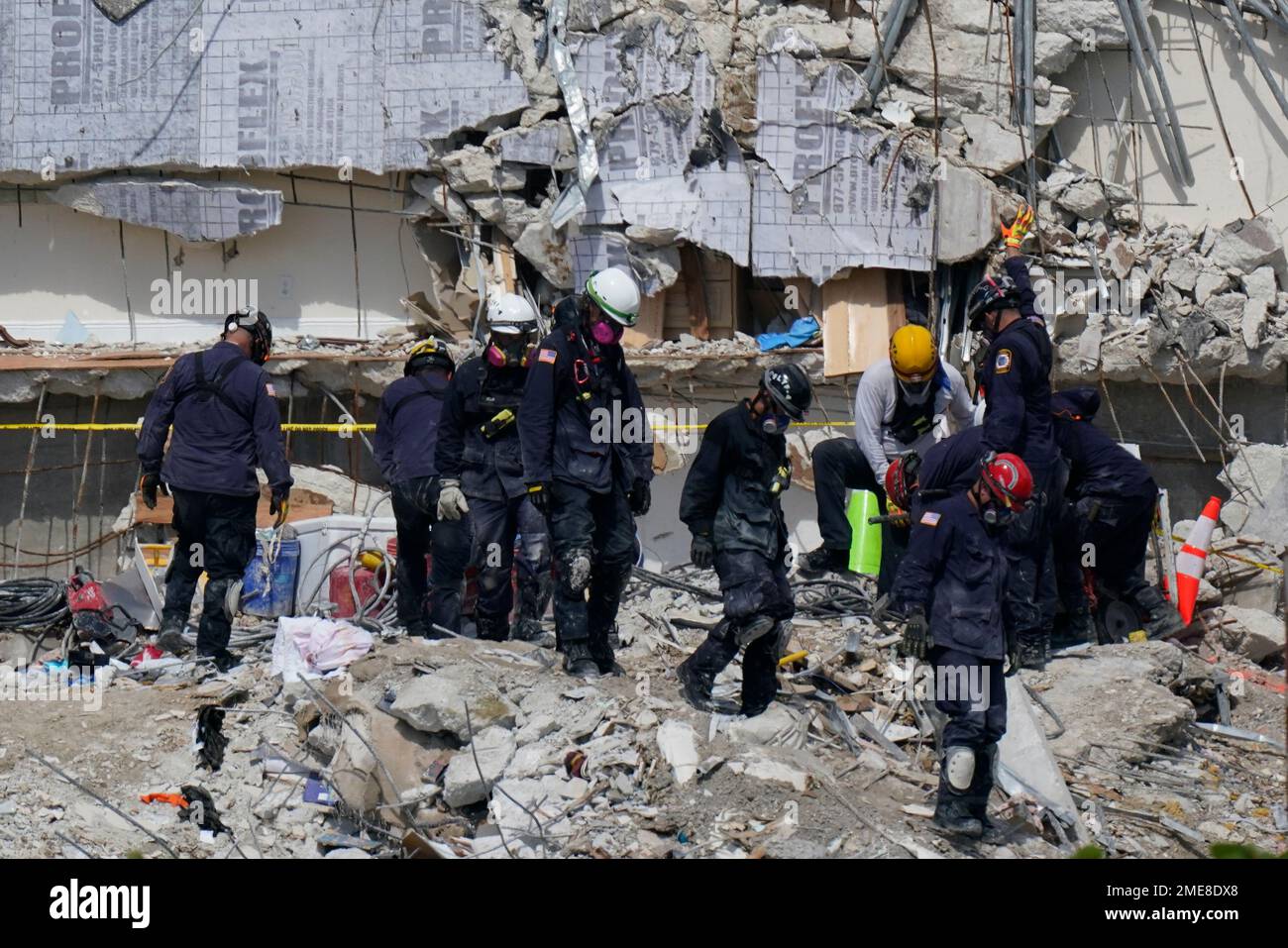 Search and rescue personnel work atop the rubble at the Champlain ...